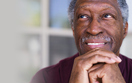 man with hands folded looking up