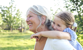 Women giving granddaughter a piggy back ride